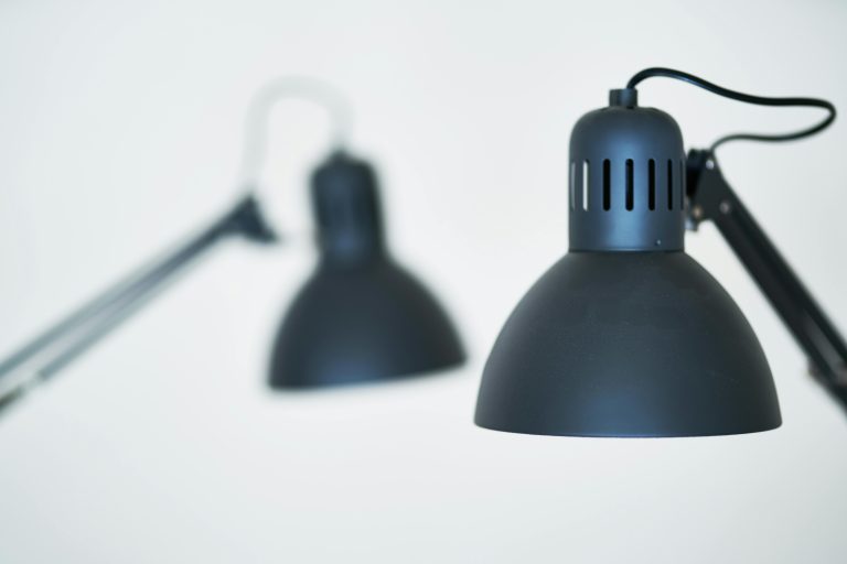 Minimalist close-up of contemporary black desk lamps in a studio setting.